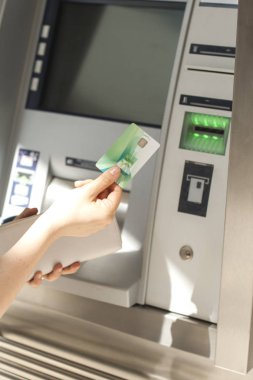 Bir kadın sokakta bir Atm de kredi kartı kullanır. Para ile çalışma. Ödeme. Kopya alanı