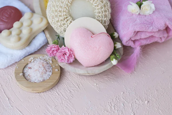 Spa ve banyo aksesuarları. Fotoğraf pembe renklerde. Canlı çiçekler ve sabun. Sakin ol. Uzay kopyalayın. Düz yatıyordu