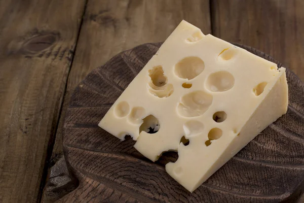 Bellissimo formaggio olandese con buchi, un prodotto lattiero-caseario sano. Cibo gustoso. Foto in stile country. Posto per il testo. Copia spazio — Foto Stock