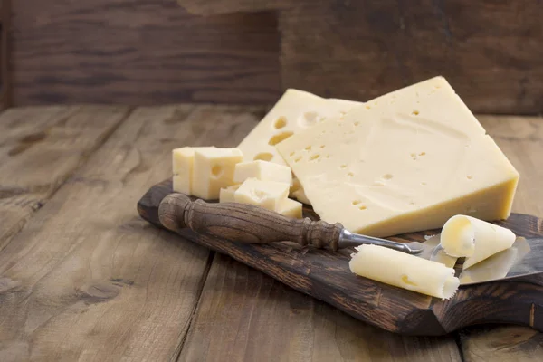 Güzel bir İsviçre peyniri delikli, yararlı bir süt ürünü. Lezzetli yemekler. Ülke tarzı fotoğraf. Metin için yer. Kopya alanı — Stok fotoğraf