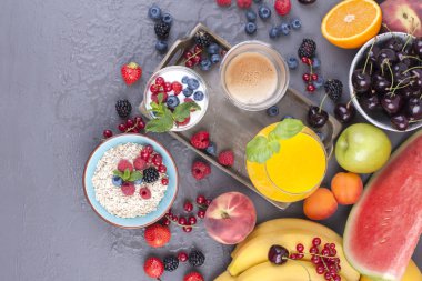 Birçok farklı meyve ve çilek. Vitamin ve sağlıklı gıda. Portakal suyu bir bardak, yoğurt, müsli çilek ve güzel kokulu sabah kahve ile. Lezzetli kahvaltı. Kopya alanı