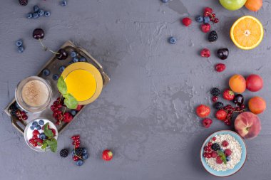 Birçok farklı meyve ve çilek. Vitamin ve sağlıklı gıda. Portakal suyu bir bardak, yoğurt, müsli çilek ve güzel kokulu sabah kahve ile. Lezzetli kahvaltı. Kopya alanı