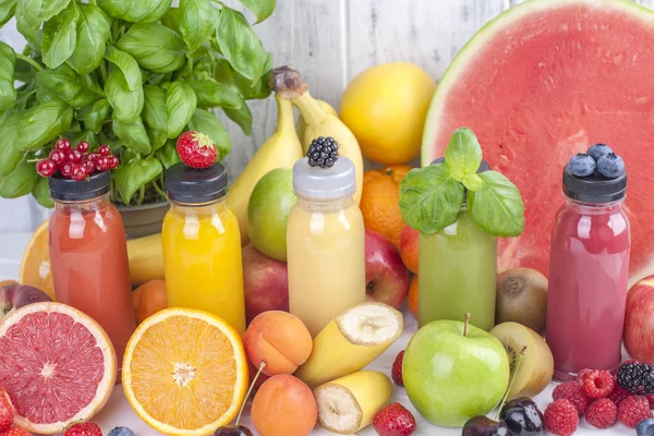 Birçok farklı meyve ve çilek, suyu şişelerde. Vitamin ve sağlıklı gıda. Yaz ürünleri. Kopya alanı