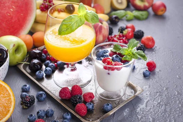 많은 다른 과일 및 열매. 비타민과 건강 식품 여름 제품과 유리에서 오렌지 주스입니다. 요구르트와 muesli 열매와. 맛 있는 아침 식사. 공간 복사 — 스톡 사진