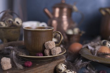 Bir fincan hoş kokulu kahve ve kahverengi şeker. Vintage Fotoğraf. Yumurta tavuk ve bıldırcın ve tüy. Paskalya. Fotoğraf bir rustik tarzda. Kopya alanı