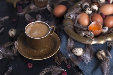 Bir fincan hoş kokulu kahve ve kahverengi şeker. Vintage Fotoğraf. Yumurta tavuk ve bıldırcın ve tüy. Paskalya. Fotoğraf bir rustik tarzda. Kopya alanı