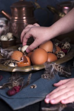 Çocuk eller çerçeve, Paskalya yumurtaları irili ufaklı, tüyler. Vintage tarzı fotoğrafta. Kırsal aksesuarları. Kopya alanı