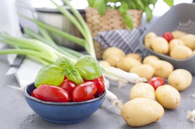 Taze yeşil soğan, Genç patates, domates ve Yeşil fesleğen. Sağlıklı gıda ve vitamin. Öğle Yemeği hazırlanması. Yaz mevsim sebzeleri. Kopya alanı