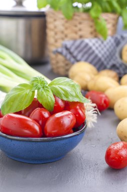 Taze yeşil soğan, Genç patates, domates ve Yeşil fesleğen. Sağlıklı gıda ve vitamin. Öğle Yemeği hazırlanması. Yaz mevsim sebzeleri. Kopya alanı