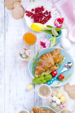 Arka plan Paskalya. Salata ve espresso ile kahvaltı Croissants için. Taze meyve suyu ve tatlılar. Bahar lale. Paskalya dekor. Beyaz ahşap zemin.