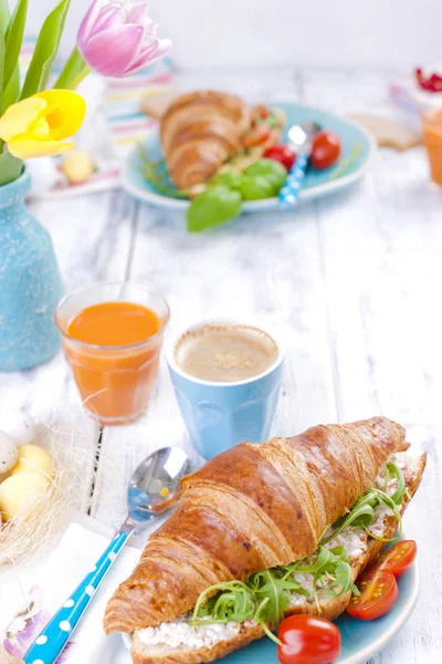 Beyaz bir arka plan üzerinde lezzetli bahar kahvaltı. Taze lale buketi. Küçük ve büyük renkli Paskalya yumurtaları. Yulaf ezmesi, kahve, taze çilek.