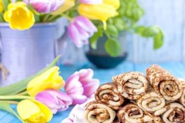 Ev yapımı reçel bahar karnaval için geleneksel krep. Rus kahvaltı. Lale parlak çiçekler. Mavi arka plan. Metin veya bir kartpostal için boş alan