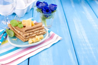 Parmesan ve bahar karnaval için fesleğen ile ev yapımı geleneksel gözleme. İtalyan kahvaltısı. Lale parlak çiçekler. Mavi arka plan. Metin veya bir kartpostal için ücretsiz bir yer.