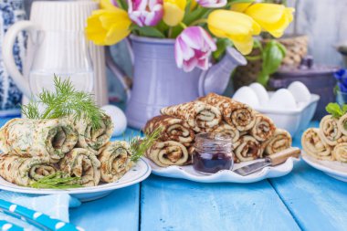 İnce krep farklı dolguları ile bahar Rus tatil için. Geleneksel yemekleri. Wessing kahvaltı. Paskalya ve karnaval. Parlak lale buketi. Mavi arka plan. Metin için kartı yer.