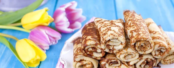 Ev yapımı reçel bahar karnaval için geleneksel krep. Rus kahvaltı. Lale parlak çiçekler. Mavi arka plan. Metin veya bir kartpostal için boş alan