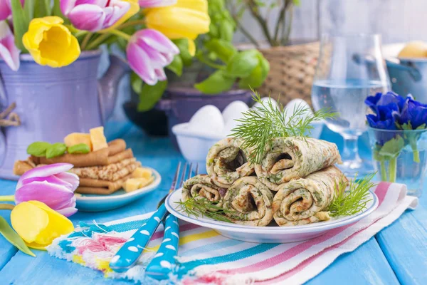 Bahar karnaval için dereotu ile ev yapımı geleneksel gözleme. Rus kahvaltı. Lale parlak çiçekler. Mavi arka plan. Metin veya bir kartpostal için ücretsiz bir yer.
