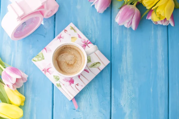 Manhã de primavera, café perfumado e tulipas de cor amarela e rosa. Donuttsy copia. Fundo de madeira azul, lugar para texto e cartão postal . — Fotografia de Stock