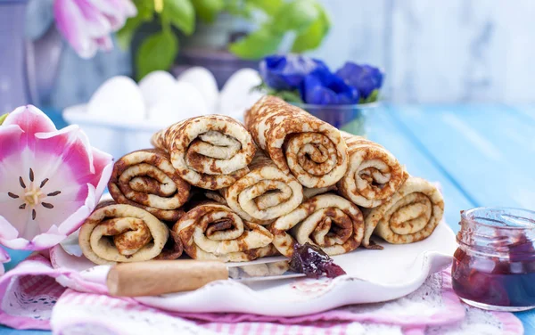 Ev yapımı reçel bahar karnaval için geleneksel krep. Rus kahvaltı. Lale parlak çiçekler. Mavi arka plan. Metin veya bir kartpostal için boş alan.