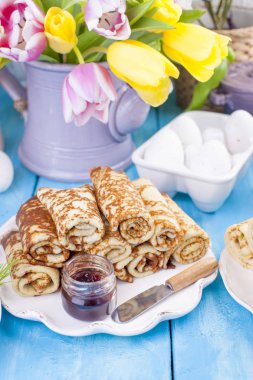 Ev yapımı reçel bahar karnaval için geleneksel krep. Rus kahvaltı. Lale parlak çiçekler. Mavi arka plan. Boş alan metin veya bir posta kartı için. Kopya alanı.