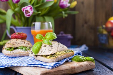 Sandviç ile taze avokado, fesleğen, domates ve peynir ile İtalyanca alır. Karanlık bir arka plan üzerinde yemek sağlıklı bir kahvaltı. Metin veya kartpostal için ücretsiz yer.