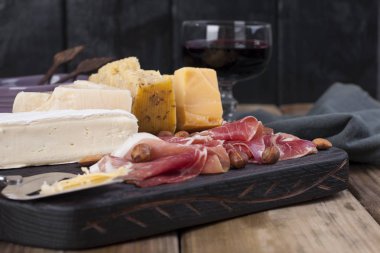 Çeşitli peynir, et, zeytin ve bir cam şarap. Lezzetli İtalyan atıştırmak için bir parti. Kopya alanı