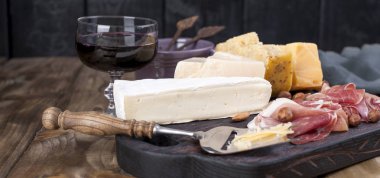 Çeşitli peynir, et, zeytin ve bir cam şarap. Lezzetli İtalyan atıştırmak için bir parti. Kopya alanı