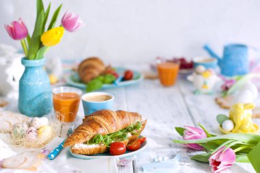 Paskalya kahvaltı düz yatırın, kızarmış yumurta ve bıldırcın yumurtası ve bahar tatil dekorasyon renkli gre, tost ekmek. Üstten görünüm. Uzay kopyalayın. kruvasan kahvaltı için. Metin veya kartpostal için boş alan.