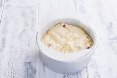 Kırmızı meyveler için ev yapımı pasta hamur içinde. Çelik bir kase içinde. Beyaz ahşap arka plan ve metin için boş alan