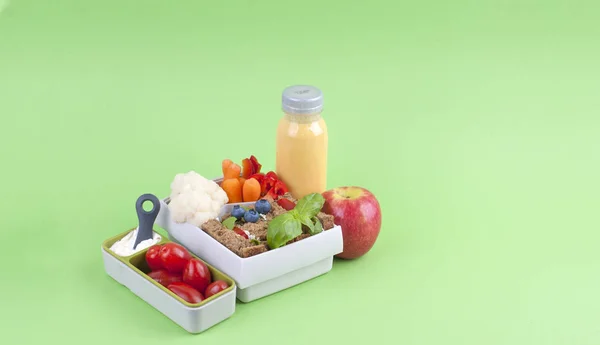 Office Lunch in einer Box und Saft mit Früchten auf grünem Hintergrund. Freiraum für Text. Kopierraum — Stockfoto