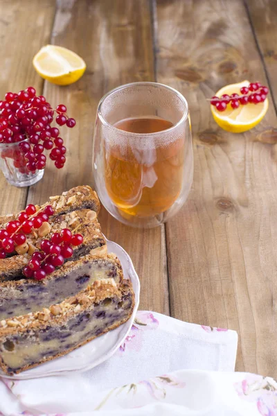 Sweet home-made pie with berries and nuts for breakfast. Homemade baking. Berries of red currants and lemon. Brown wooden background. Free me for text or postcard