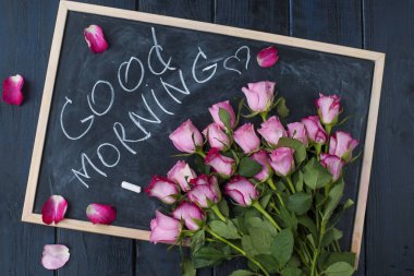 Bir kara tahta üzerinde taze pembe gül buketi. St Sevgililer Günü Bayramı için. Kartpostal için metin