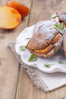 Hurma, kahvaltıda peçeteye beyaz bir yemek ile ev yapımı hamur işleri. Ahşap masa. Metin veya reklam için boş alan