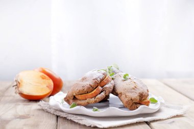 Kahvaltı için taze hurma ile ev yapımı hamur işleri plaka peçete üzerinde beyaz. Ahşap masa. Metin veya reklam için boş alan