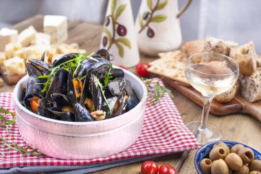 Kırmızı peçeteye beyaz seramik kase müsli. Ahşap bir tahta ve bir bardak beyaz şarap ve zeytin peynir. Ahşap bir arka plan üzerinde. Metin veya reklam için boş alan