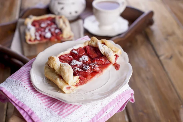 Sweet home-made pie for breakfast and a cup of black tea, on a krchovom wooden tray. free space for text or advertising