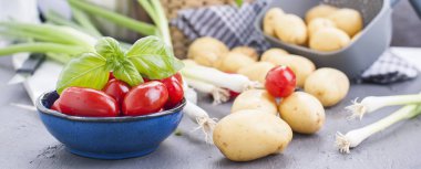 Genç patates, küçük kiraz domates, yeşil soğan ve yemek için fesleğen. Sağlıklı beslenme için sebze. Kopya alanı