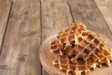 Ahşap plaka günü kahvaltıda tatlı Belçika Waffle. Homemade Pişirme. Kahverengi ahşap zemin üzerinde. Metin veya reklam için boş alan