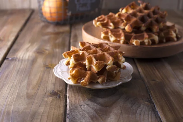 Sweet Belgische wafels voor het ontbijt, op een houten plaat. Op een bruin houten achtergrond — Stockfoto