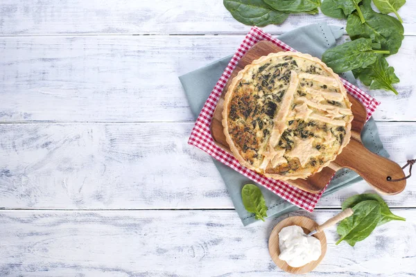 Torta fatta in casa con spinaci e formaggio, su uno sfondo di legno bianco. porzione di torta — Foto Stock