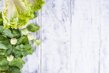 farklı taze yeşil sebze, sebze ve Brüksel lahanası. Beyaz ahşap zemin üzerinde. metin yazma yer.