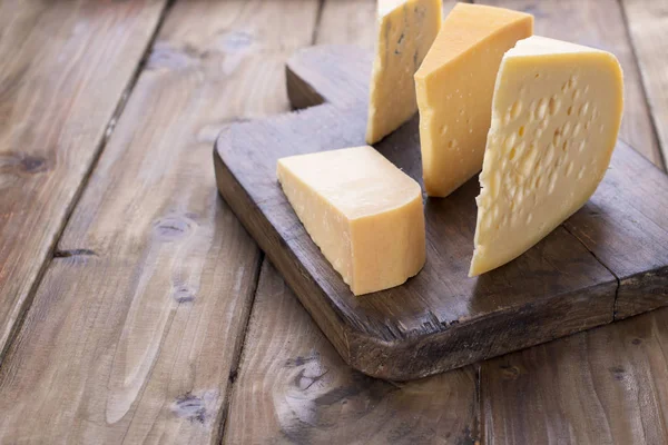 Eski bir ahşap tahta üzerinde farklı peynir klasik seçim — Stok fotoğraf