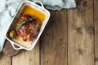 ip ile bağlı et pişmiş bir kabuk bir fırın tepsisine limon ve biberiye, ahşap masa ve havlu ile için