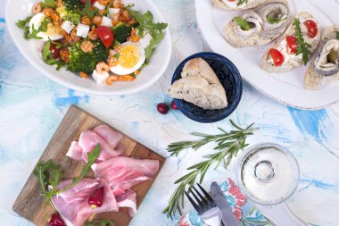 salata karides ve sebze beyaz bir tabak ve bir kadeh şarap, bir ahşap tahta ve sandviç et.