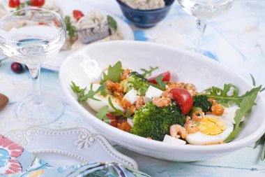 karides salatası ve beyaz bir tabak ve bir kadeh şarap, bir ahşap tahta üzerinde et sebze.