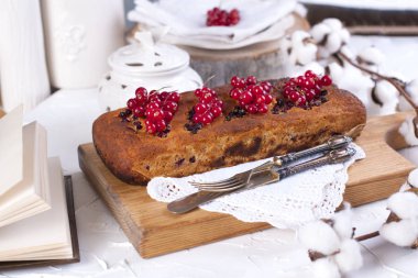 bir ahşap tahta ve beyaz arka plan, pamuk çiçek kırmızı kuş üzümü ile Cupcake.