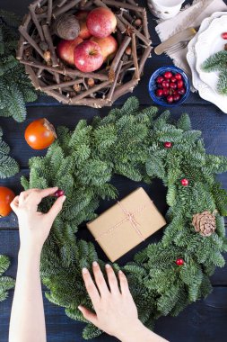 meyve, bir kadın ve bir mavi ahşap arka plan üzerinde yeşil bir Noel ağacı elinde gri kağıt hediye kutusu.