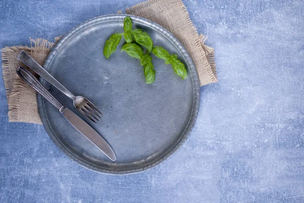 a vintage plate empty on a gray background, a table towel and a knife. Free space for text. Copy space