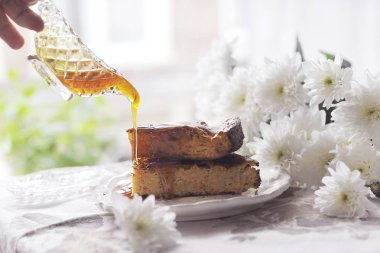 bal ile kahvaltıda kek. El bulaşıkları bal ile tutar. açık bir pencere sen-ebilmek görmek şehir sabah,