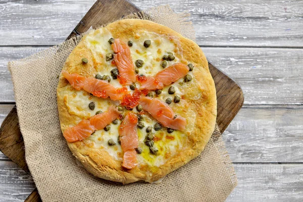 Pizza with salmon and basil and capers. Traditional Italian pastries. Copy space — Stock Photo, Image