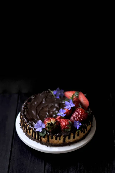 Bolo de chocolate com bagas em um fundo preto. doces doces caseiros — Fotografia de Stock